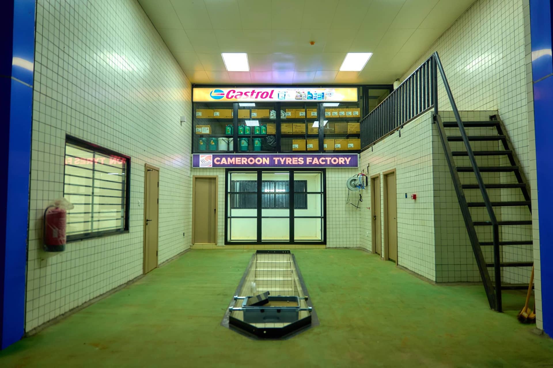 Intérieur de l’atelier : fosse, lubrifiants Castrol et pneus
