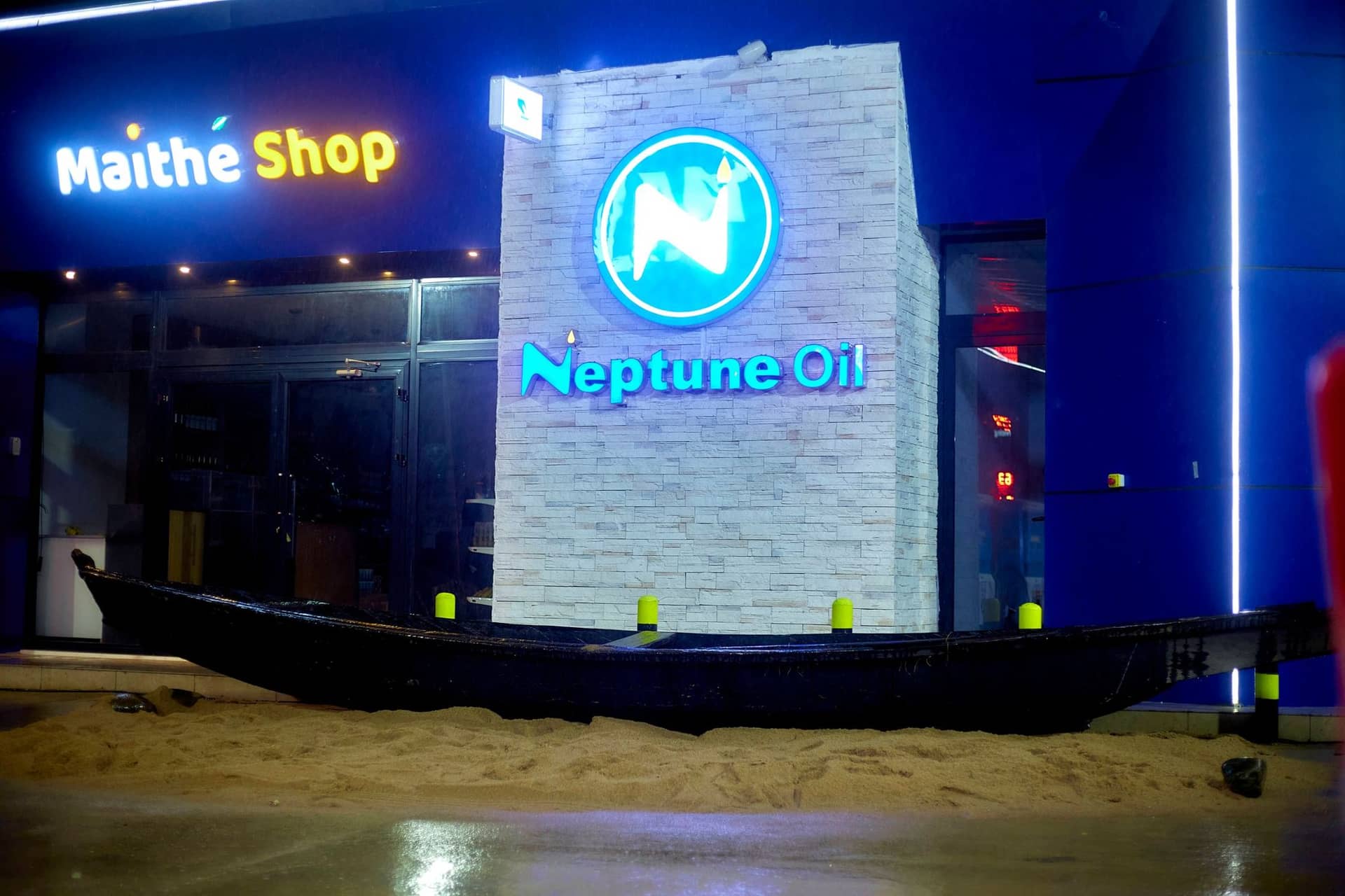 Pirogue décorative devant le Maïthé Shop et le logo Neptune Oil
